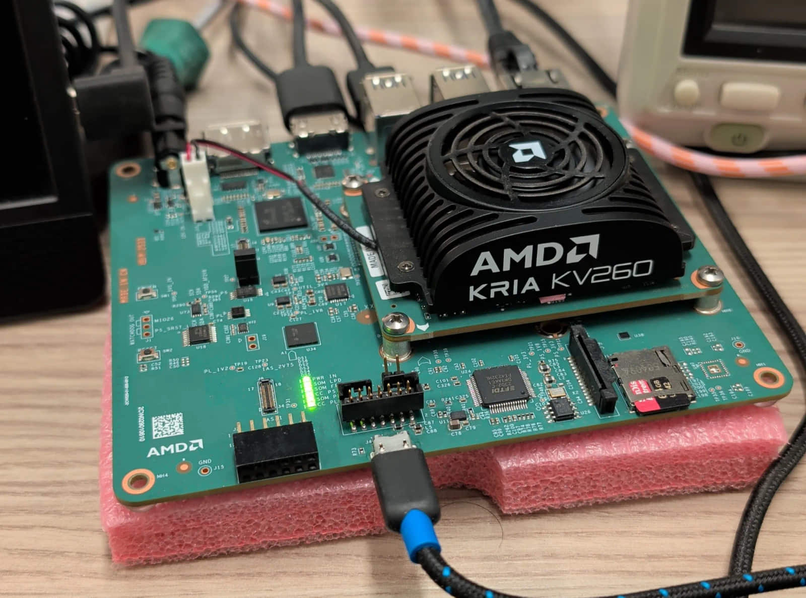 AMD Kria KV260 在实验台上。语言模型就住在那把风扇下面。