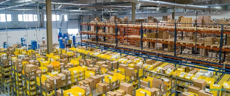 A real warehouse packed with cartons and yellow bins — ayraix.com